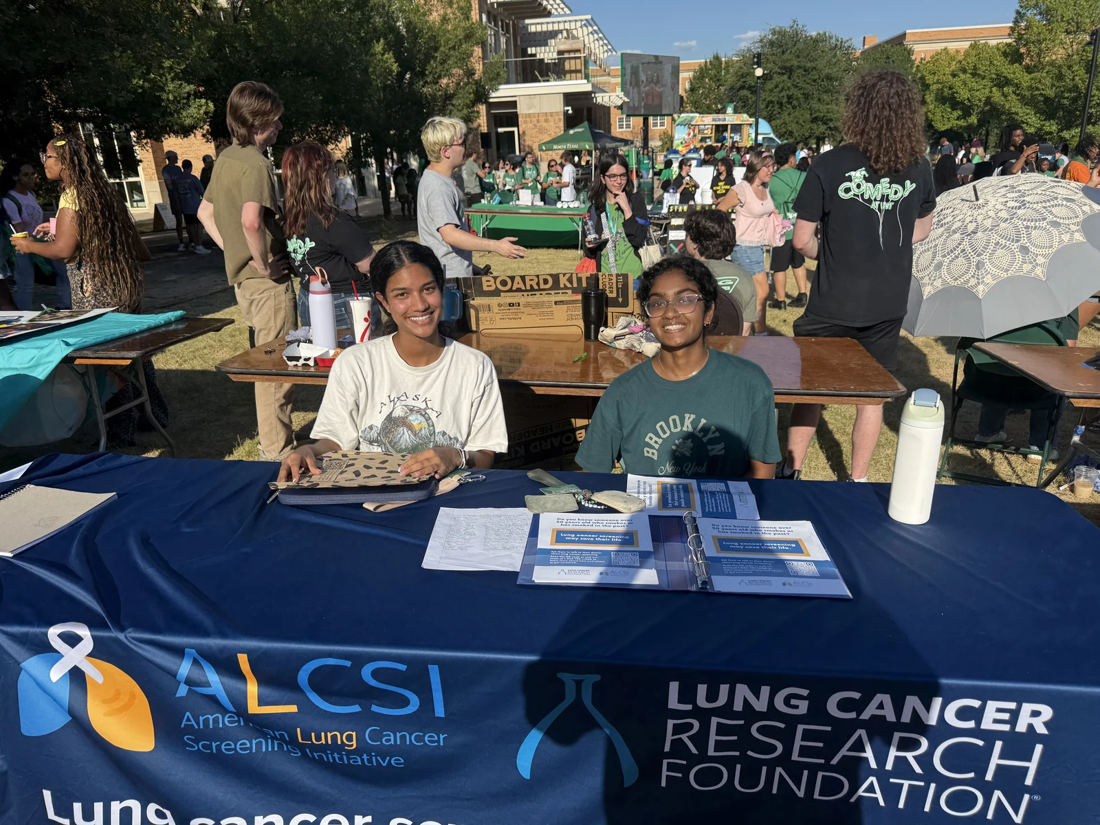 ALCSI volunteers welcoming visitors at a community screening information table