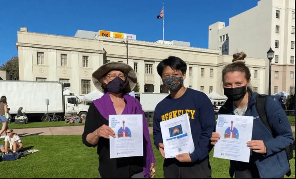 Masked ALCSI volunteers sharing screening information outside