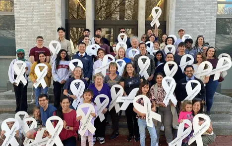 A large group of ALCSI advocates holding white ribbons