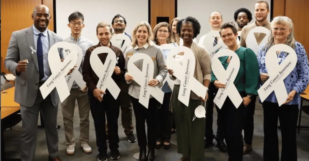 Clinicians and advocates gathered with white ribbons