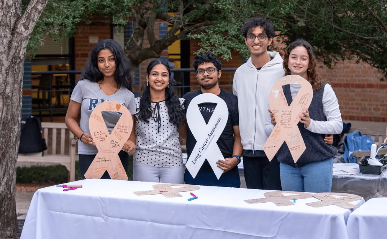 ALCSI volunteers holding white ribbons at an outdoor event