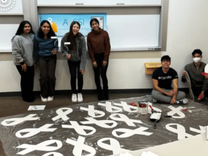 ALCSI volunteers preparing white ribbons for an awareness event