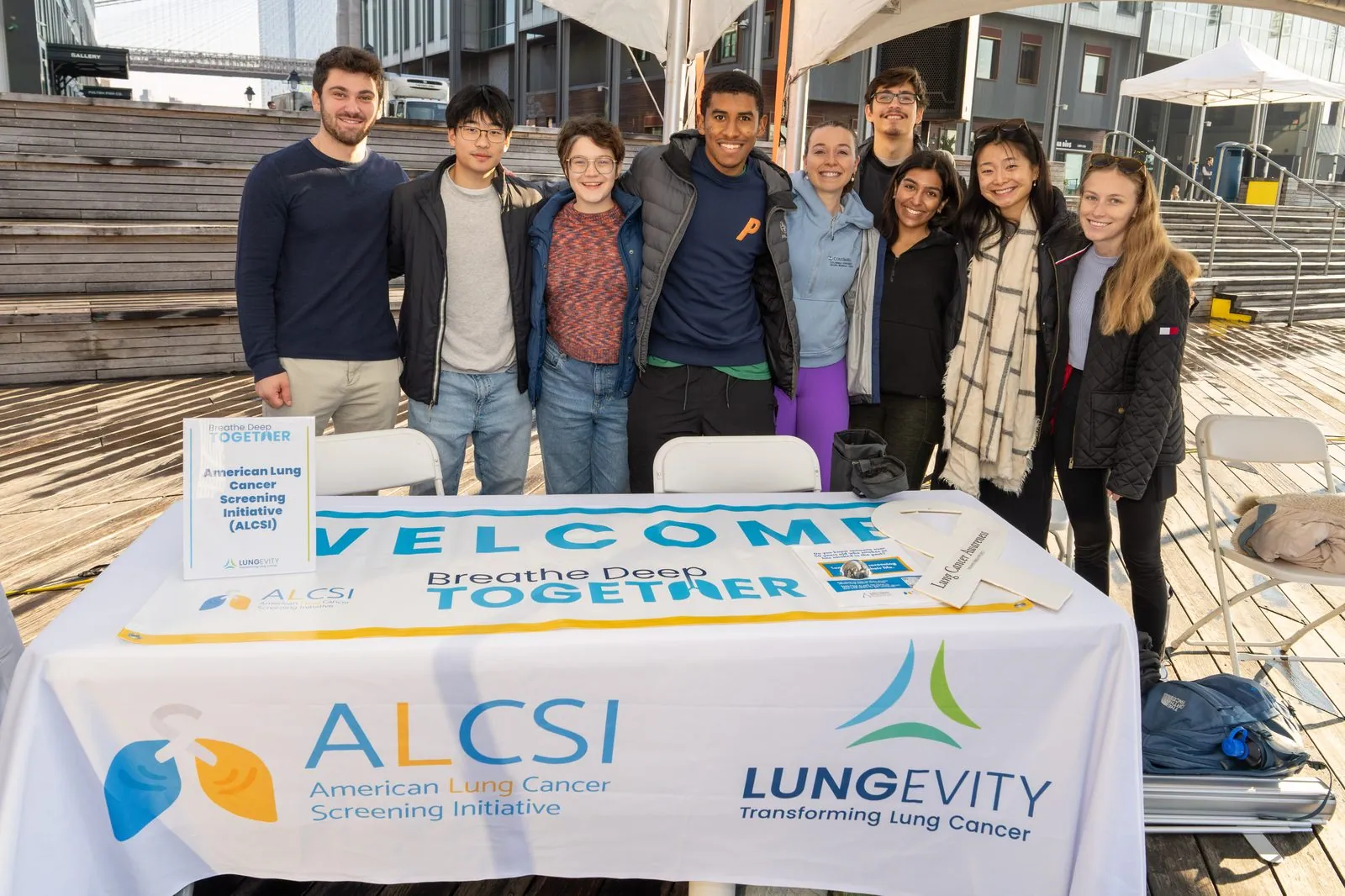 ALCSI volunteers behind an information table at a community event