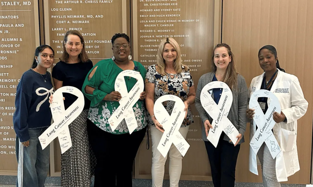 Advocates holding white lung cancer awareness ribbons