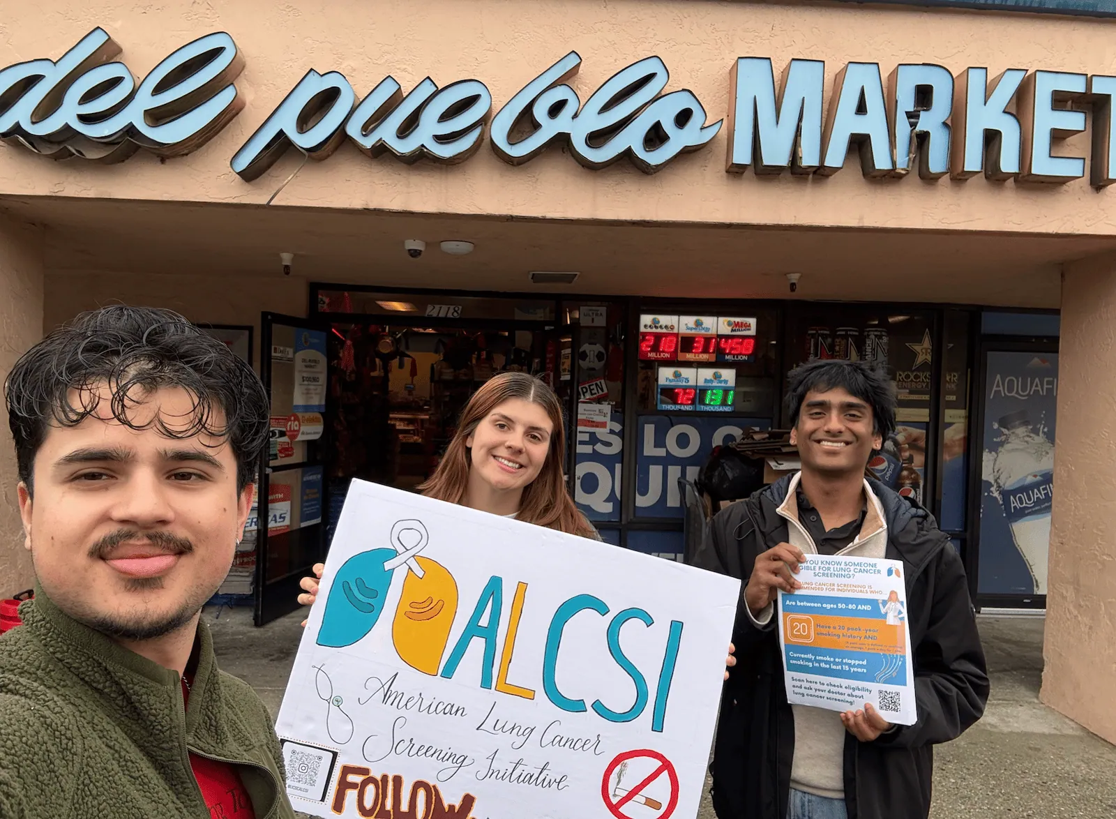 ALCSI members holding a screening awareness sign in a public market