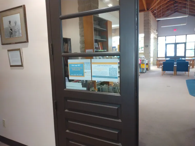 ALCSI screening flyers displayed on a library glass door