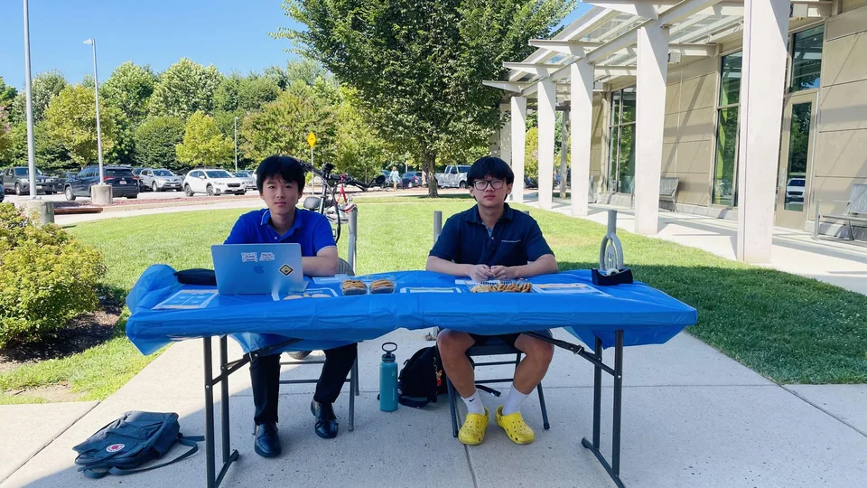 Two Centennial High School students at an ALCSI table outside Miller Branch Library