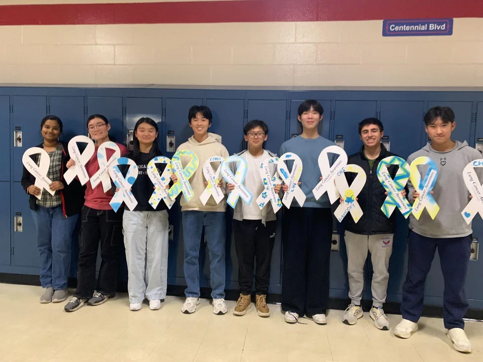 Centennial High School students holding white ribbons in a school hallway