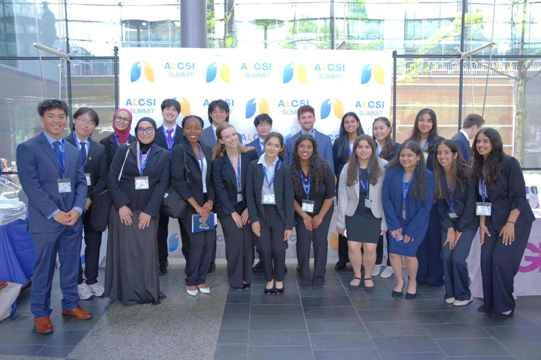 Summit attendees gathered in front of an ALCSI backdrop